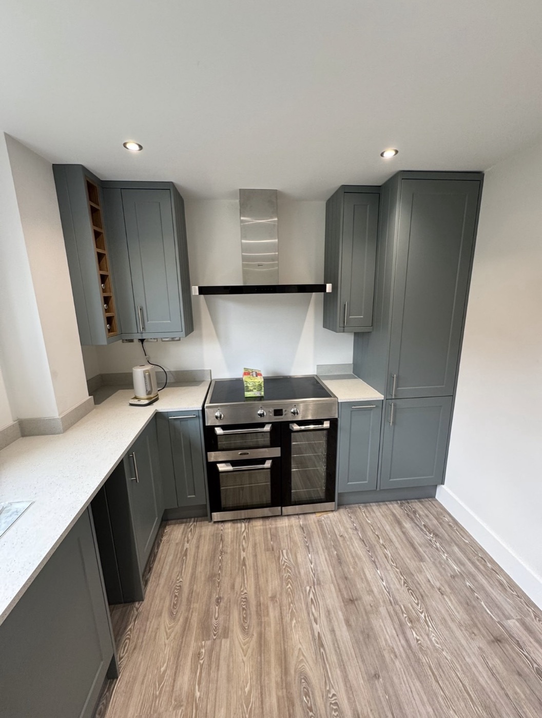 Sage-grey shaker kitchen with wine rack fitted for Graham Morris